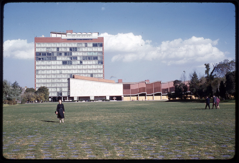 A photographic slide of Evelyn Crabtree standing in the campus of a large building.