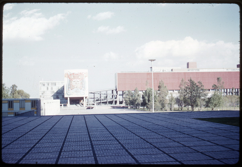 A photographic slide of a series of buldings, one adorned with a psychedelic-inspired painting.