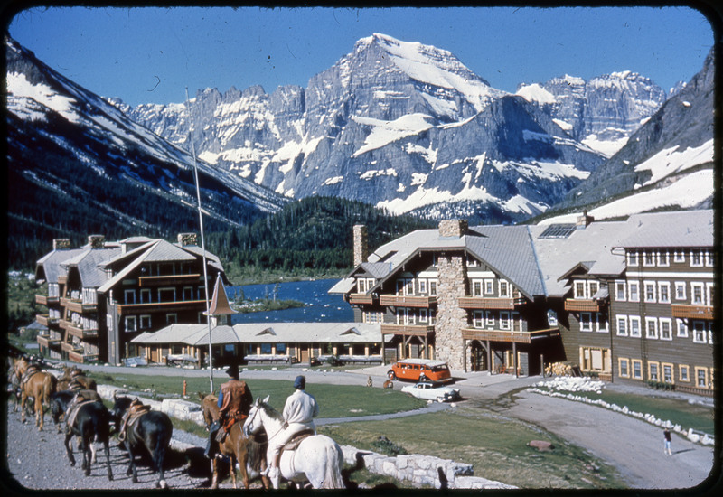 A photographic slide of an alpine lake with a large mountain behind it. There are other mountains in the background. The mountain is reflected in the lake.