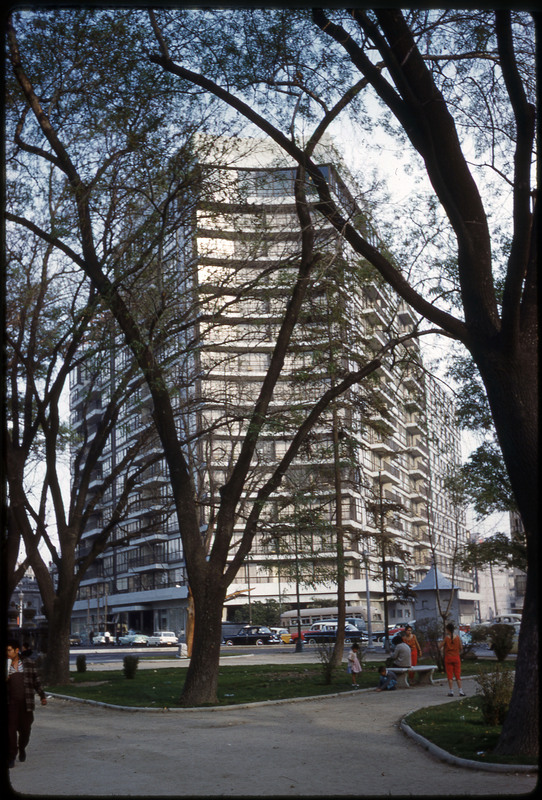 A photographic slide of a tall, curved building.