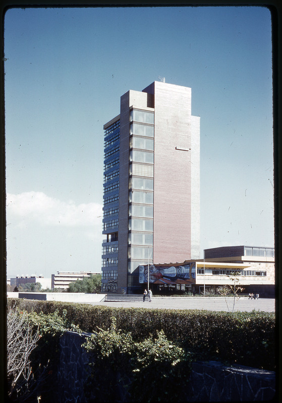 A photographic slide of a tall building on an urban campus.