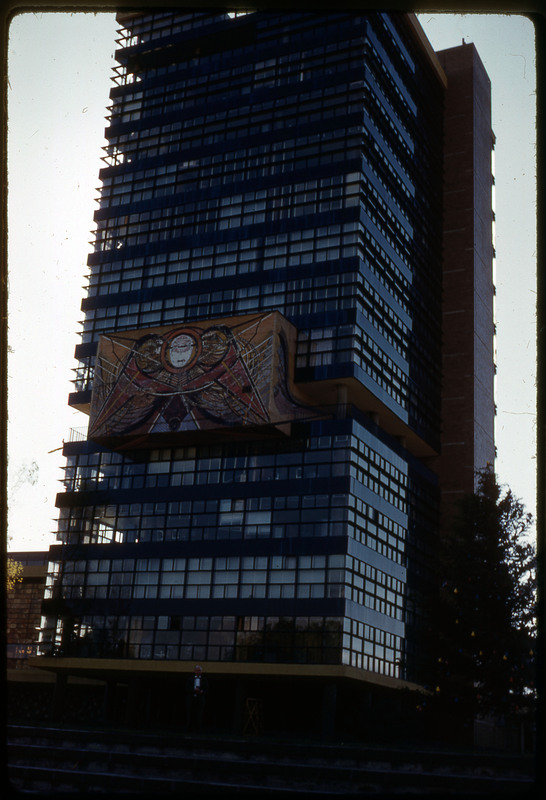 A photographic slide of a piece of abstract art displayed on the side of a tall building.