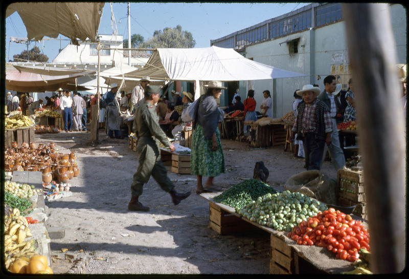 A photographic slide of a crowded outdoor marketplace.