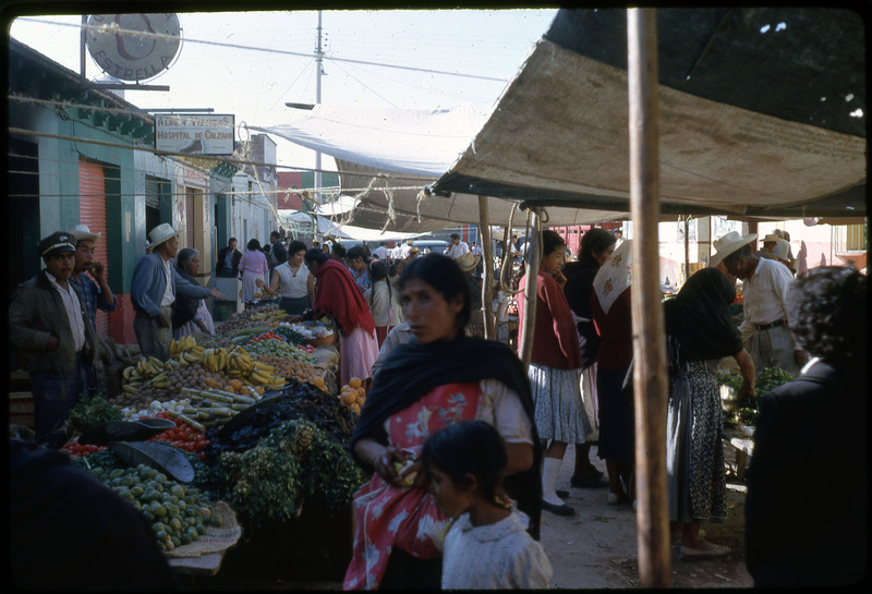 A photographic slide of a crowded outdoor marketplace.