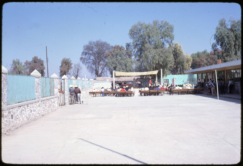 A photographic slide of a small seated gathering of people in an urban square.