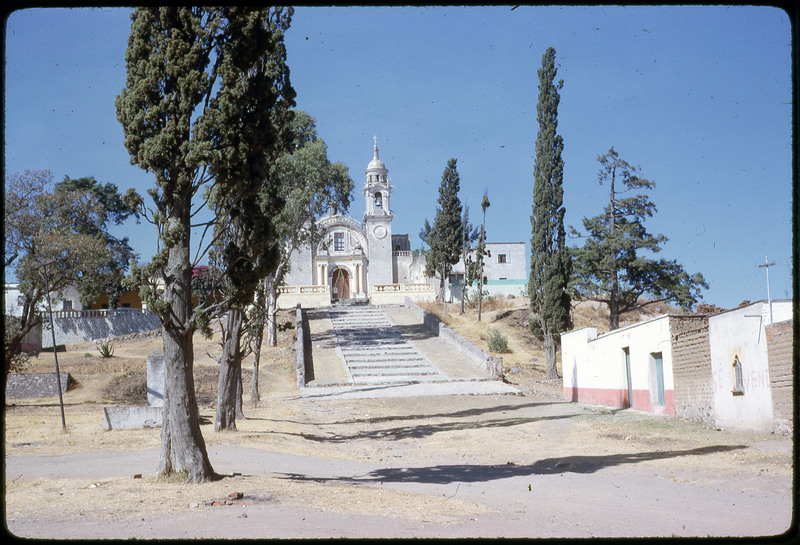 Photographic slide of a nice building with a large staircase in front. There are trees on the sides of the walkway. The building could be a church or other sort of important building.