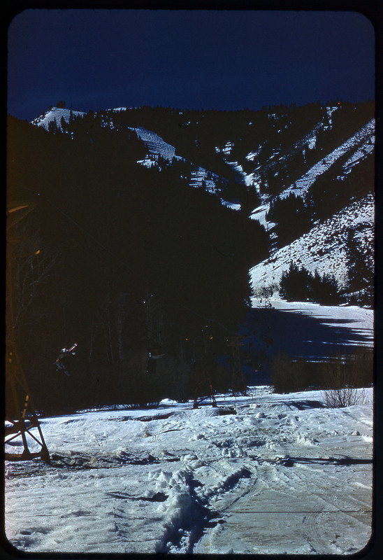 A photographic slide of snowy mountains and what looks like a ski lift up the mountain.
