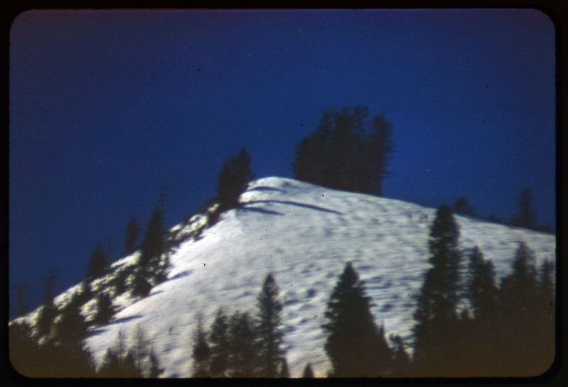 A photographic slide of snowy mountains and what looks like a ski lift up the mountain. This resembles the same photo as CE_B81_F8-Item14.