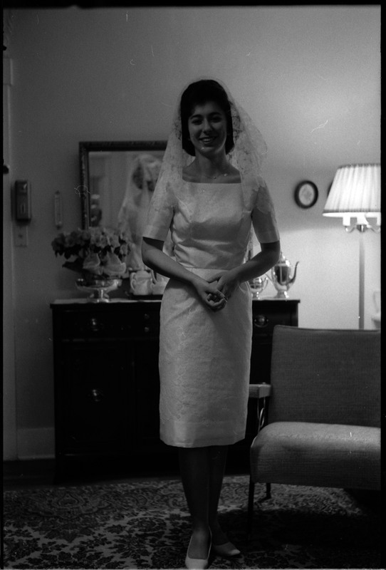 A photo of a woman wearing a wedding dress and smling for the camera. Associated with item numbers: ce_b83_f1-item1-017 through ce_b83_f1-item1-036.
