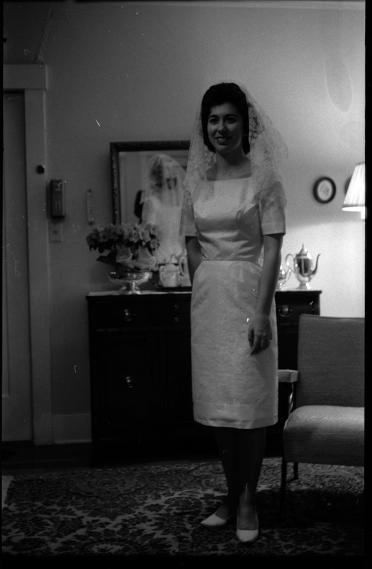 A photo of a woman wearing a wedding dress and smling for the camera. Associated with item numbers: ce_b83_f1-item1-017 through ce_b83_f1-item1-036.