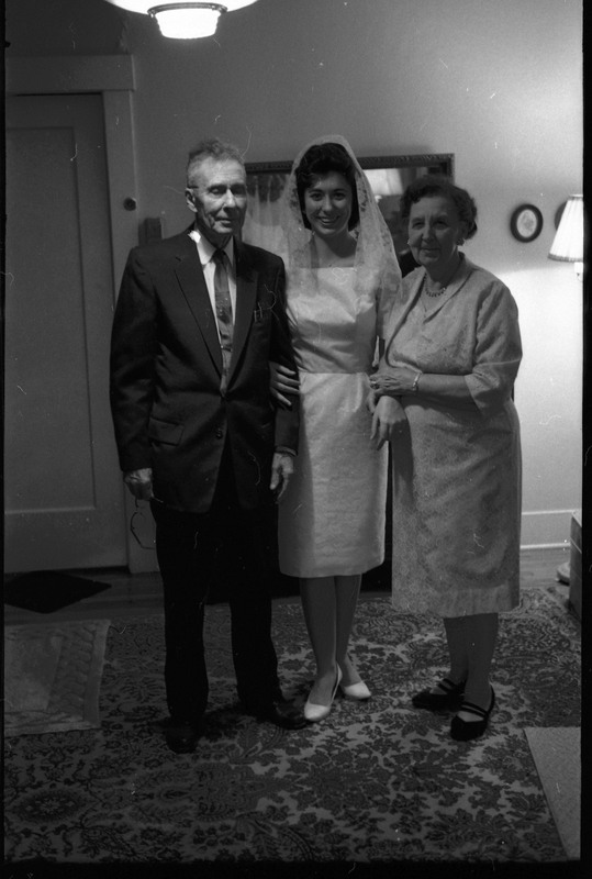 A photo of three people, including a woman wearing a wedding dress, posing for the camera. Associated with item numbers: ce_b83_f1-item1-017 through ce_b83_f1-item1-036.