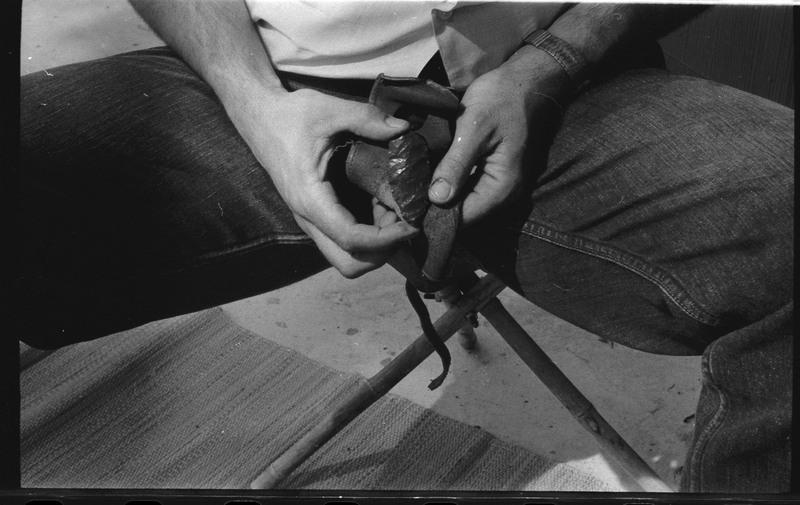 A photo of a pair of hands, holding a flintknapped piece. Associated with item numbers: ce_b83_f2-item1-004 through ce_b83_f2-item1-024.