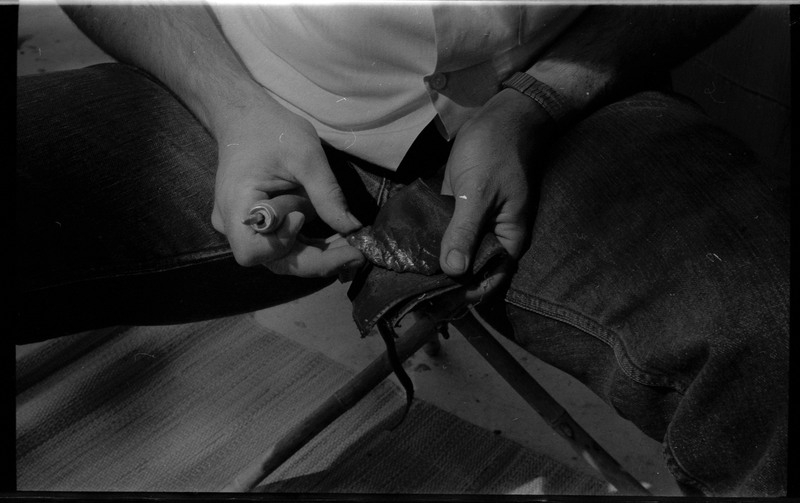A photo of a pair of hands, holding a flintknapped piece and flintknapping tools. Associated with item numbers: ce_b83_f2-item1-004 through ce_b83_f2-item1-024.