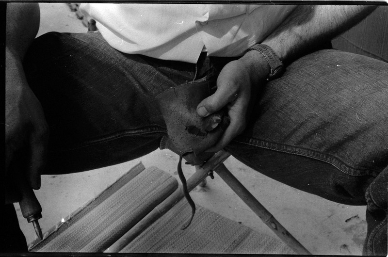 A photo of a pair of hands, holding flintknapping tools. Associated with item numbers: ce_b83_f2-item1-004 through ce_b83_f2-item1-024.