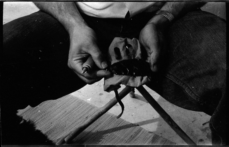 A photo of a pair of hands, holding a flintknapped piece and flintknapping tools. Associated with item numbers: ce_b83_f2-item1-004 through ce_b83_f2-item1-024.