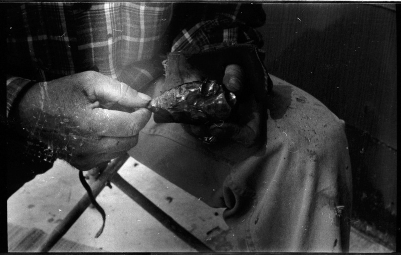 A photo of a pair of hands, holding a flintknapped piece. Associated with item numbers: ce_b83_f2-item1-004 through ce_b83_f2-item1-024.