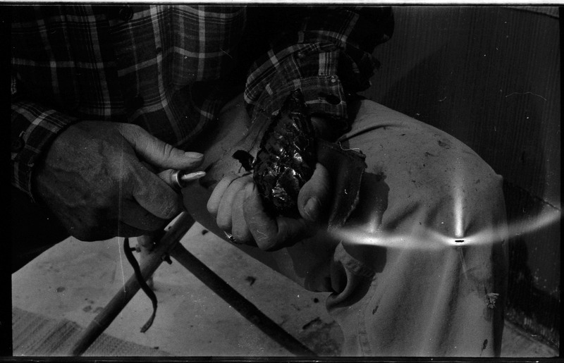 A photo of a pair of hands, holding a flintknapped piece and flintknapping tools. Associated with item numbers: ce_b83_f2-item1-004 through ce_b83_f2-item1-024.