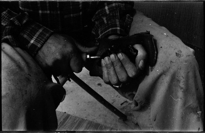 A photo of pair of hands, holding a stone and actively flintknapping. Associated with item numbers: ce_b83_f2-item1-004 through ce_b83_f2-item1-024.