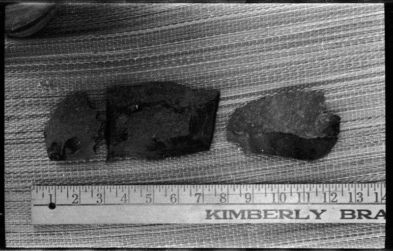 A photo of three flintknapped pieces next to a ruler.