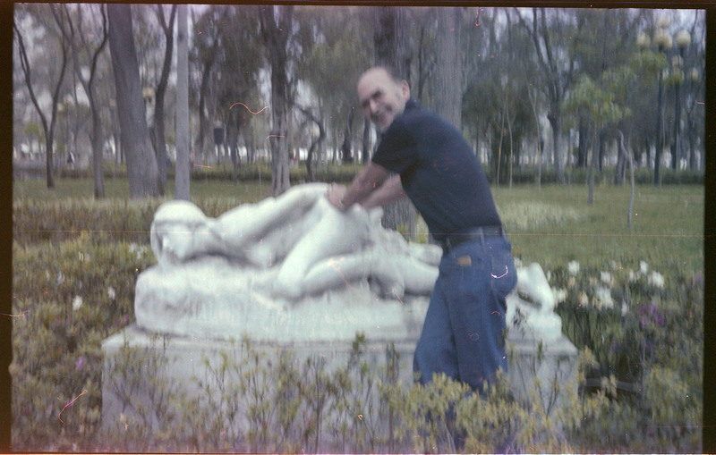 A photo of Donald Crabtree posing in front of a statue.
