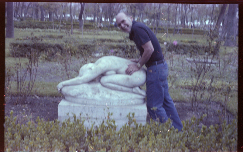 A photo of Donald Crabtree posing in front of a statue.