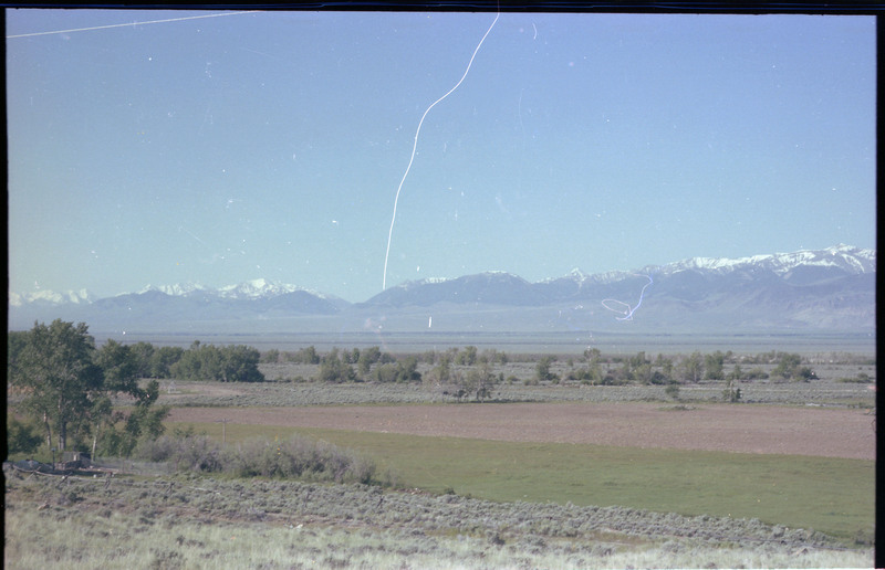 A photo of a landscape with snowcapped mountains in the distance.