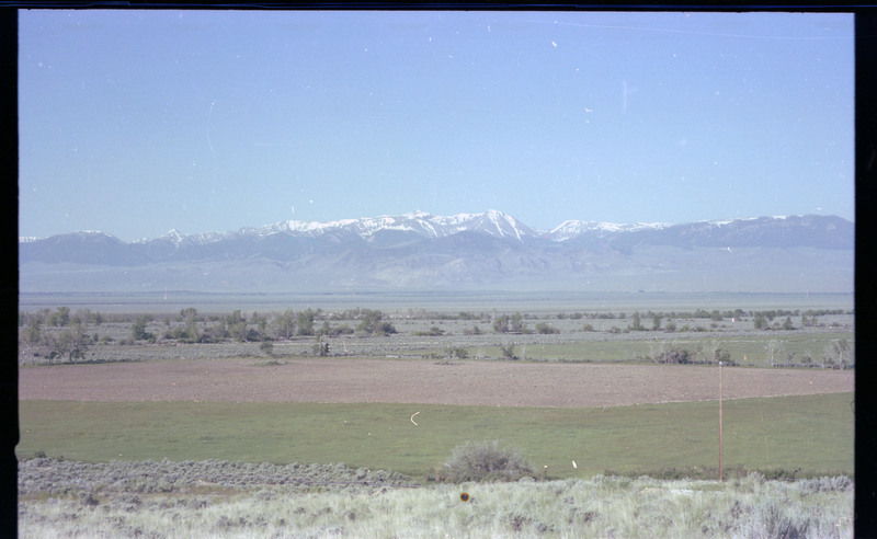 A photo of a landscape with snowcapped mountains in the distance.