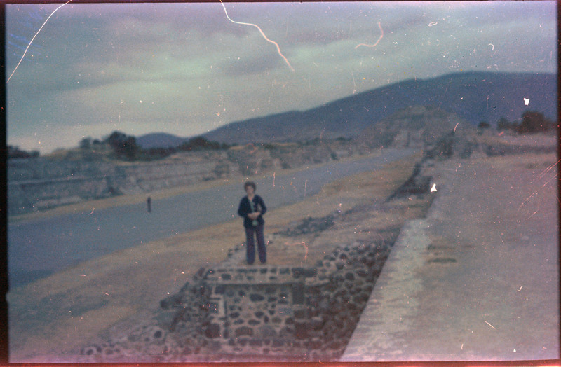 A photograph of Evelyn Crabtree standing on a stone wall.