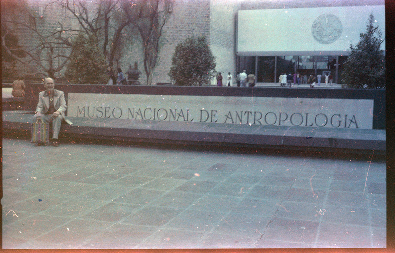 A photograph of Donald Crabtree sitting outside the Museo Nacional de Antropologia in Mexico.