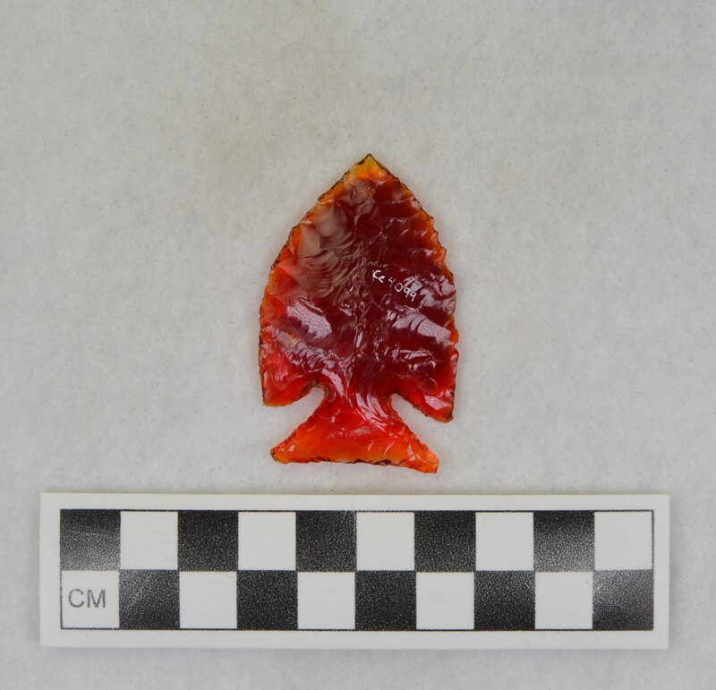 A corner notched, biface created from glass of a broken tail light lens. (JW)