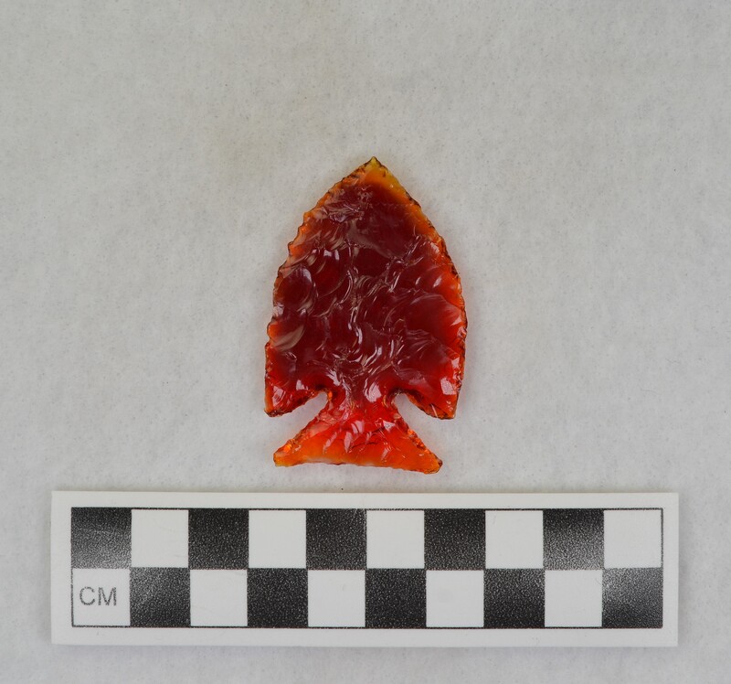 A corner notched, biface created from glass of a broken tail light lens. (JW)