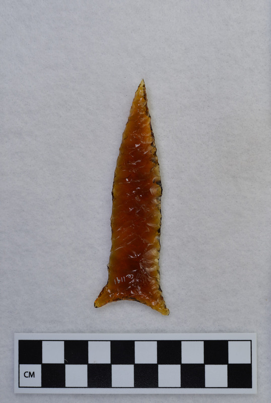 Donald E. Crabtree used the bottom of an old, brown glass, Clorox bottle. He used the Titmus technique of parallel diagonal flaking to make this biface.