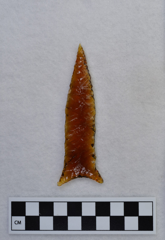 Donald E. Crabtree used the bottom of an old, brown glass, Clorox bottle. He used the Titmus technique of parallel diagonal flaking to make this biface.