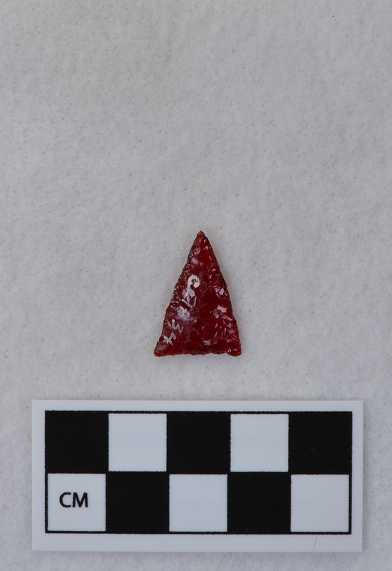A triangular point created by Donald E. Crabtree from the glass of a red tail light lens. (JW)