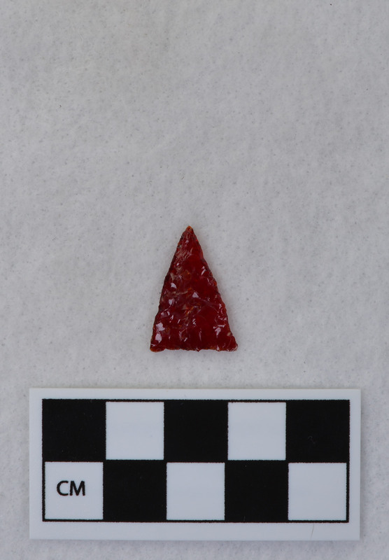 A triangular point created by Donald E. Crabtree from the glass of a red tail light lens. (JW)