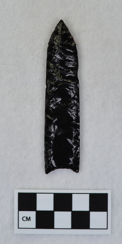 Fluted by pressure flaking, Ground almost full length of margin to facilitate holding in a vise. (JW)