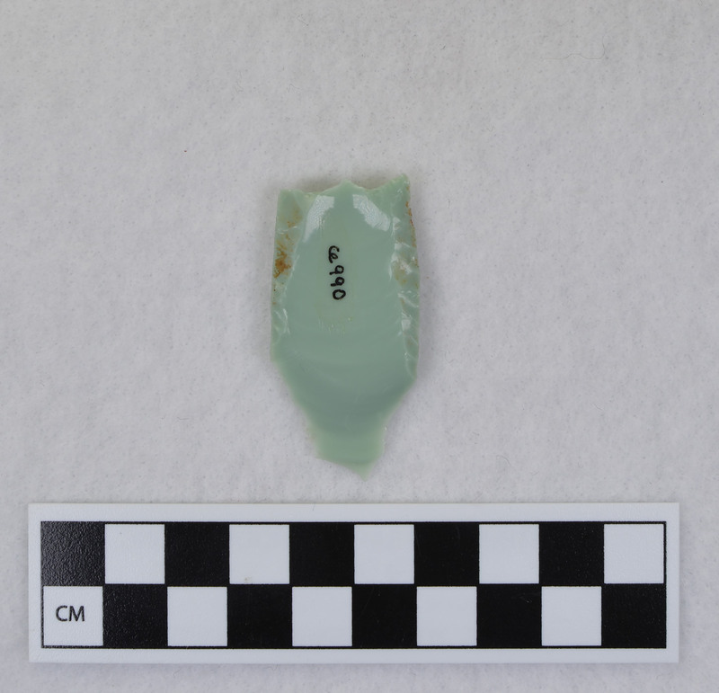 Donald E. Crabtree created this object during his Folsom fluting experiments. This example is broken, and shows evidence that the edges and distal end were ground. Crabtree's blood can be seen on the object. Gene Titmus said that this object was created while being held in a vise during fluting process. Point flexed during flute removal causing distal end snipping. (GT) Crossmends with Ce.991.