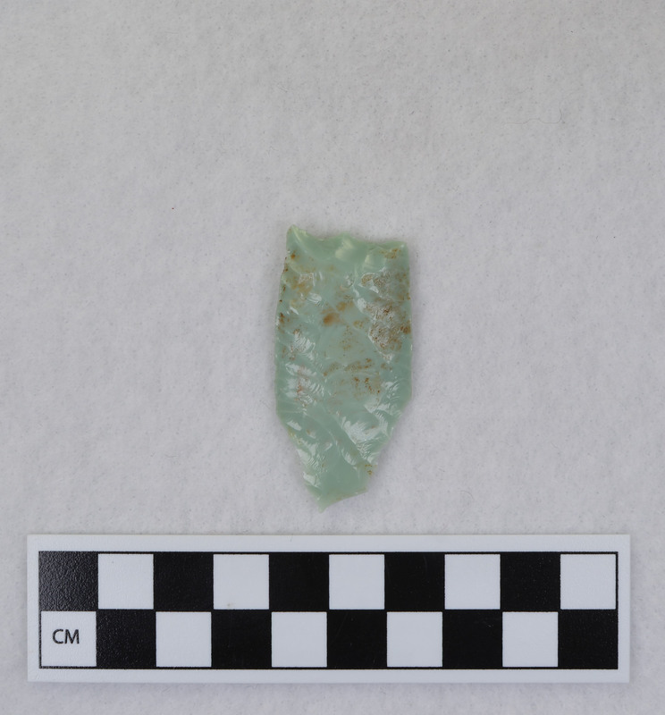 Donald E. Crabtree created this object during his Folsom fluting experiments. This example is broken, and shows evidence that the edges and distal end were ground. Crabtree's blood can be seen on the object. Gene Titmus said that this object was created while being held in a vise during fluting process. Point flexed during flute removal causing distal end snipping. (GT) Crossmends with Ce.991.