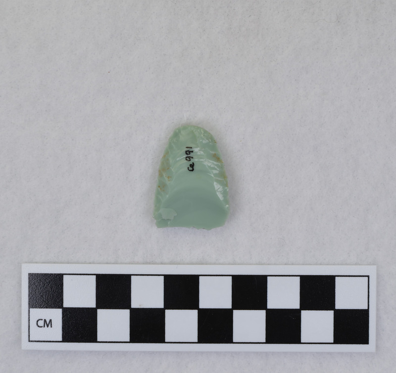 Donald E. Crabtree created this object during his Folsom fluting experiments. This example is broken, and shows evidence that the edges and distal end were ground. Crabtree's blood can be seen on the object. Gene Titmus said that this object was created while being held in a vise during fluting process. Point flexed during flute removal causing distal end snipping. (GT) Crossmends with Ce.990.