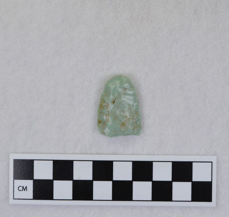 Donald E. Crabtree created this object during his Folsom fluting experiments. This example is broken, and shows evidence that the edges and distal end were ground. Crabtree's blood can be seen on the object. Gene Titmus said that this object was created while being held in a vise during fluting process. Point flexed during flute removal causing distal end snipping. (GT) Crossmends with Ce.990.