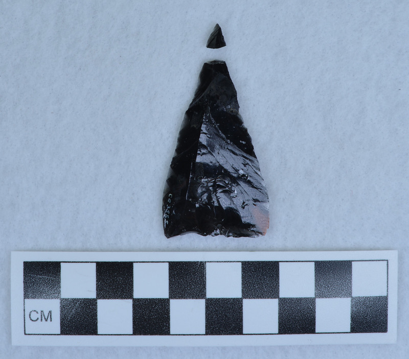 Flake altered slightly to form triangular point, Tip broken, glued. (MAP)