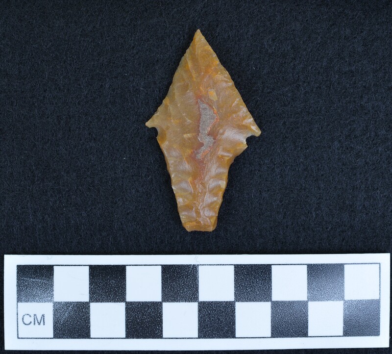 This biface was created from flint from Grand Pressigny France. The projectile point was notched, then burin flakes removed from base to notch, lastly the burin edges were pressure flaked. (GT)