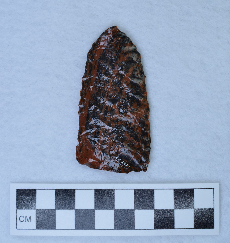 Narrow parallel diagonal flaking one face, "Other face wide collateral flaking, appears to be made from sawed slab. (GT) No saw marks apparent. (MAP)"