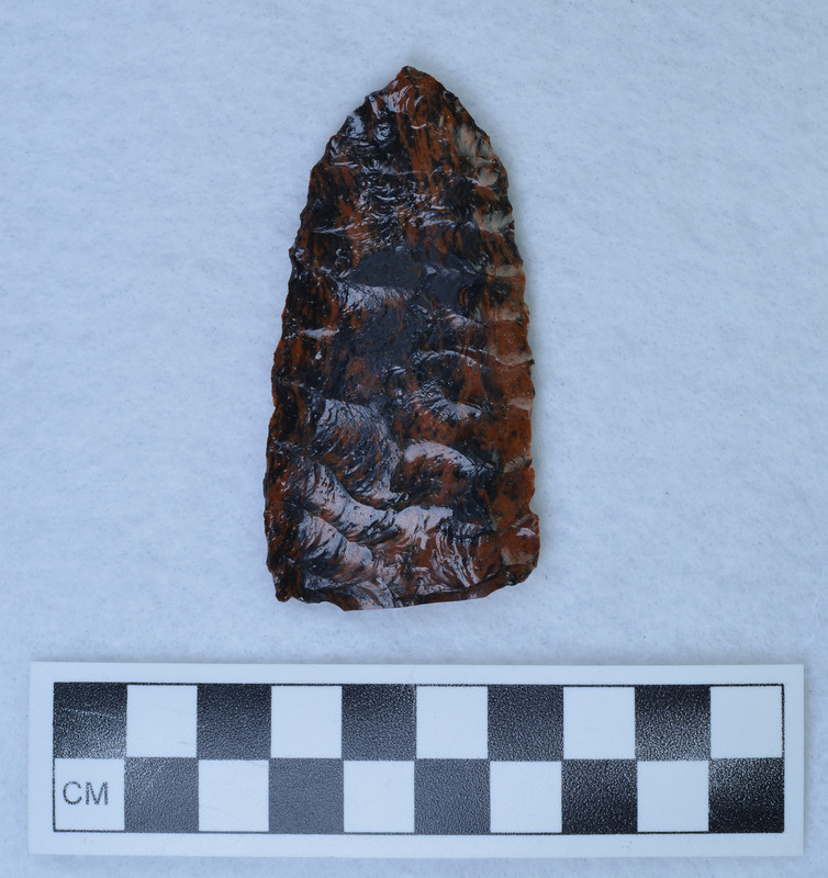 Narrow parallel diagonal flaking one face, "Other face wide collateral flaking, appears to be made from sawed slab. (GT) No saw marks apparent. (MAP)"