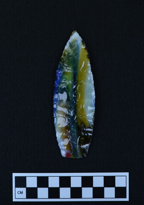 This lanceolate style point was made by Donald E. Crabtree using marbled art glass. The basal margins (base edges) were ground and thinned. The biface is made up of large collateral flakes.
