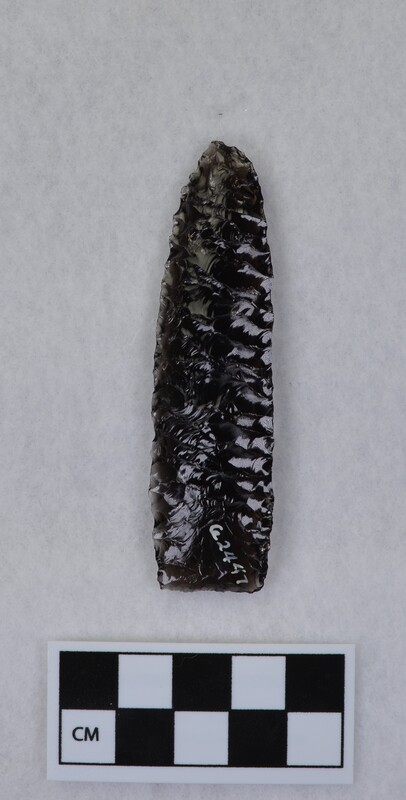 One side flakes pressed off in a punching fashion, lanceolate style, unfinished. Taking a heavier bulb and leaving a hollow ground appearance. (JW)