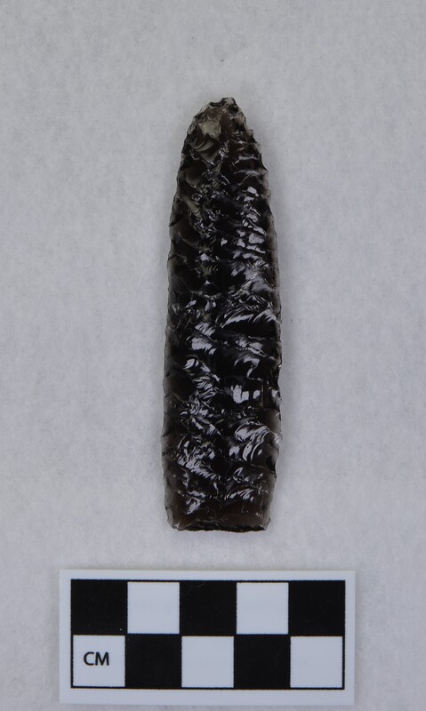 One side flakes pressed off in a punching fashion, lanceolate style, unfinished. Taking a heavier bulb and leaving a hollow ground appearance. (JW)