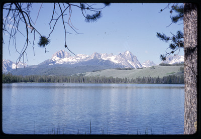 A photographic slide of a scenic view of a series of mountains behind a body of water.