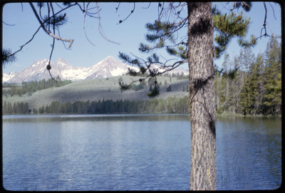 A photographic slide of a scenic view of a series of mountains behind a body of water.