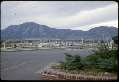 A photographic slide of a parking lot in front of a series of mountains.